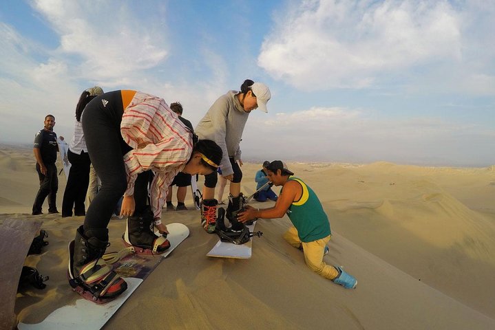 Sandboarding or Sand Ski in Huacachina Apresski bonfire Sunset