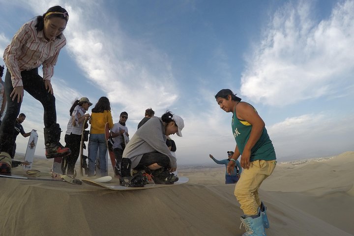 Sandboarding or Sand Ski in Huacachina Apresski bonfire Sunset