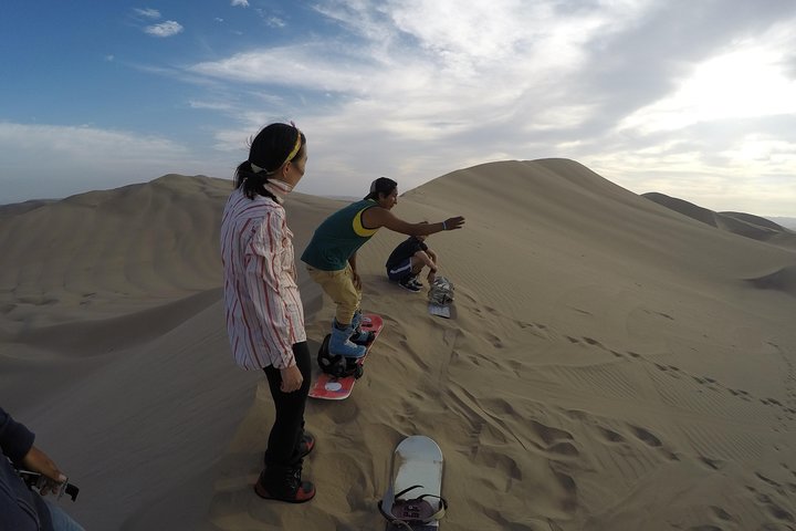 Sandboarding or Sand Ski in Huacachina Apresski bonfire Sunset