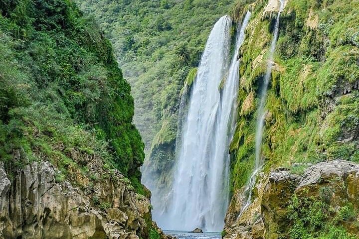 Tamul waterfall and water cave on a wooden canoe