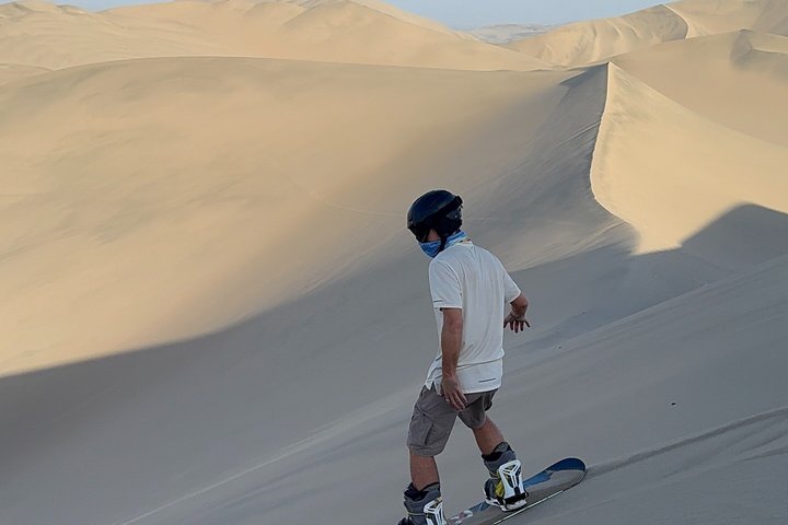 Sandboarding or Sand Ski in Huacachina Apresski bonfire Sunset